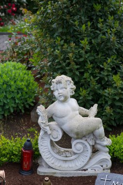 Mezar ışıklarının yanında büyük bir melek.