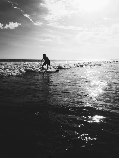 Male surfing white wash waves in Bali black and white — Stock Photo, Image