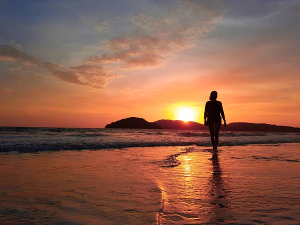Silhouette femminile che cammina in acque poco profonde al tramonto — Foto Stock
