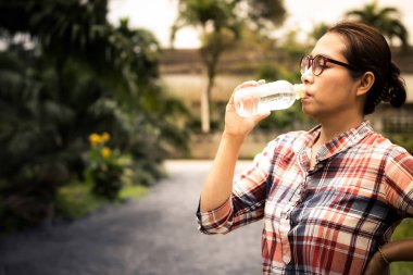Yol kenarındaki plastik şişelerde bardak su içen kadınlar