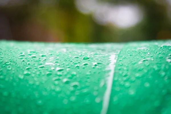 Abstract texture background of beautiful raindrop or water drops on  green-white umbrella surface, Bright colorful artistic image of nature
