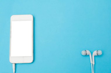 Smartphone Blank ekran, Mavi Arka Plan Üst Görünümünde Kulaklıklı beyaz