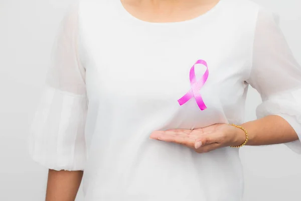 Göğüs kanserini desteklemek için kadın göğsünde pembe kurdele. Sağlık, tıp ve göğüs kanseri farkındalığı