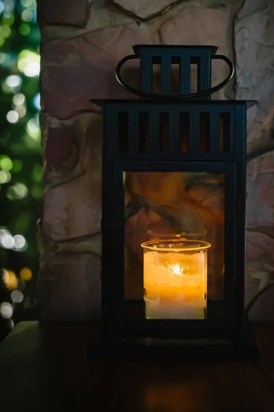 İçinde mum yanan cam kavanozlar kahve dükkanındaki siyah ahşap masalar.