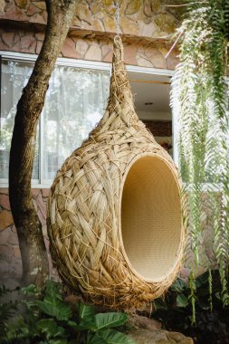 Rahatlamak için kuş yuvası şeklinde asılı bir sandalye. Doğa ve seyahat kavramı.