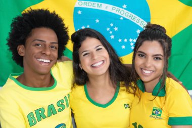 Grup üç Brezilyalı futbol taraftarları bayrak ve from Brazil formaları ile gülüyor