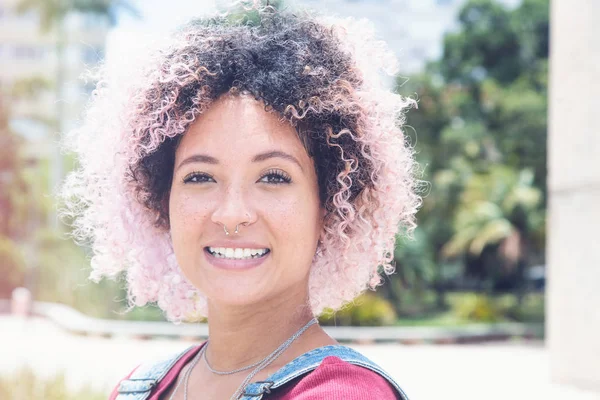 Portrait of a smiling punk girl with pink hair in vintage retro look