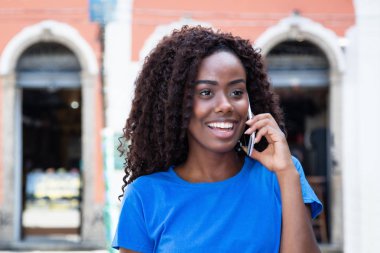 Afrikalı kadın cep telefonu açık havada şehirde eski sömürge Afrika, söz