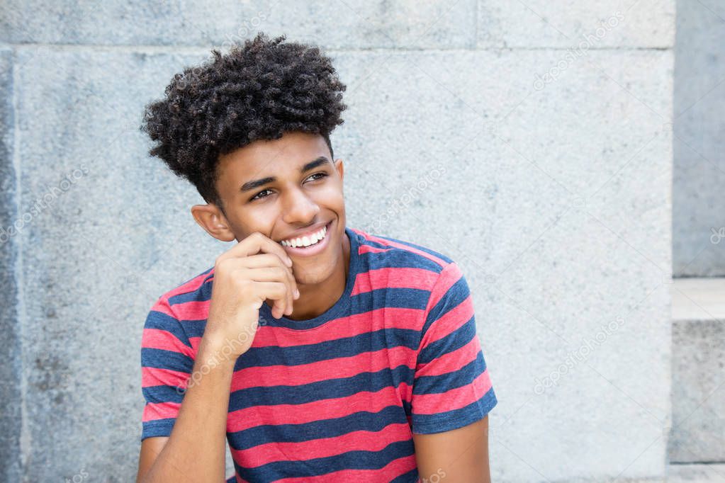 Laughing african american young adult man outdoors in the summer