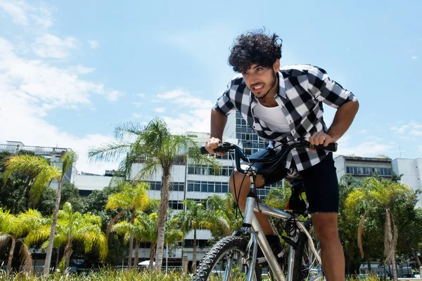 Aggressive man riding bike outdoor in the city in the summer