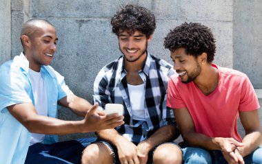 Afrikalı-Amerikalı ve beyaz hipster manstreaming film telefon açık yaz aylarında şehirde Grup