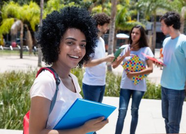 Akıllı latin Amerikalı kız öğrenci grup öğrenci, yaz aylarında Üniversitesi kampüsünde açık ile