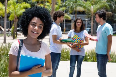 Grup öğrenci, yaz aylarında Üniversitesi kampüsünde açık ile güzel gülen latin Amerikalı kız öğrenci
