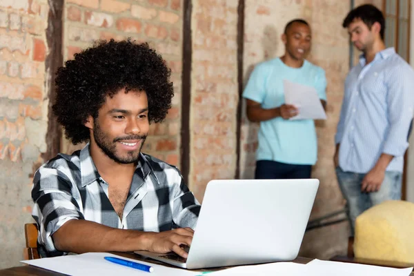 非洲裔美国人时髦软件开发商与膝上型电脑在工作在启动公司办公室 — 图库照片