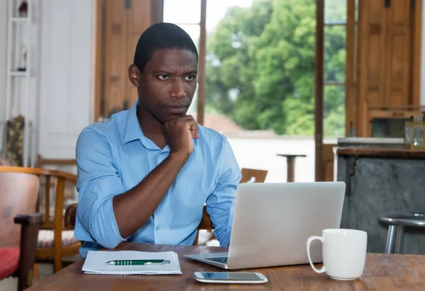 Gondolkodó Afroamerikai Férfi Laptop Otthon Pult — Stock Fotó