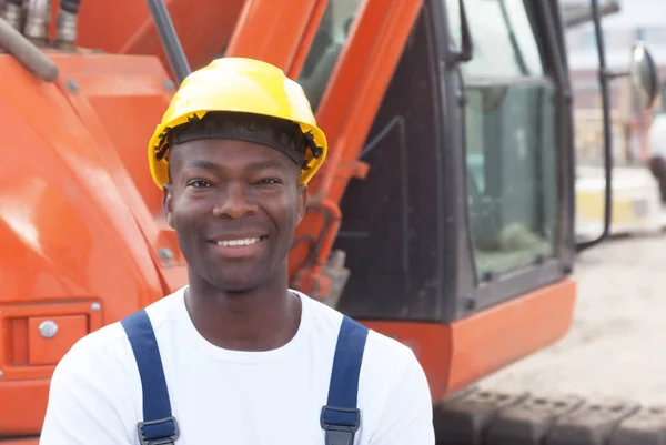 快乐的非洲建筑工人与红色挖掘机在建筑工地 — 图库照片