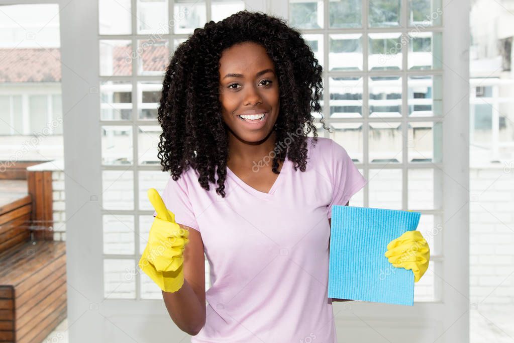 African american au pair girl cleaning room at home at flat