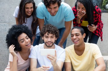 Grup Uluslararası Genç Yetişkin açık havada şehirde telefon ile oyun