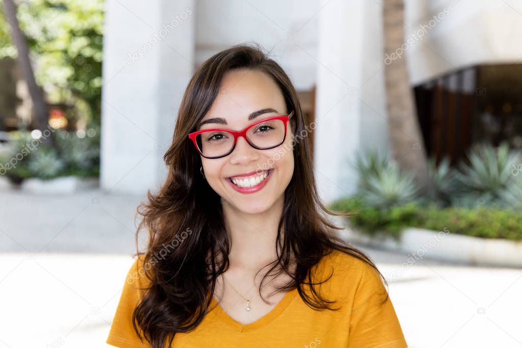 Portrait of a laughing girl with glasses outdoor in the summer in the city