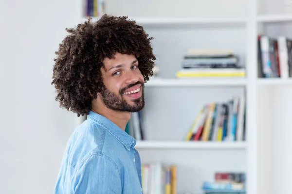 Laughing hipster man with afro hair indoor at home