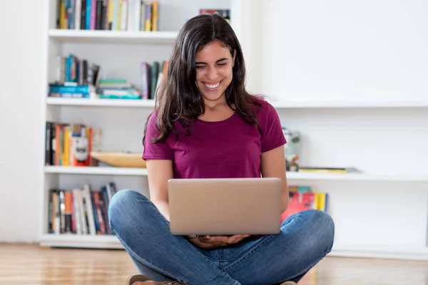 Happy indian woman shopping online with computer indoor at home