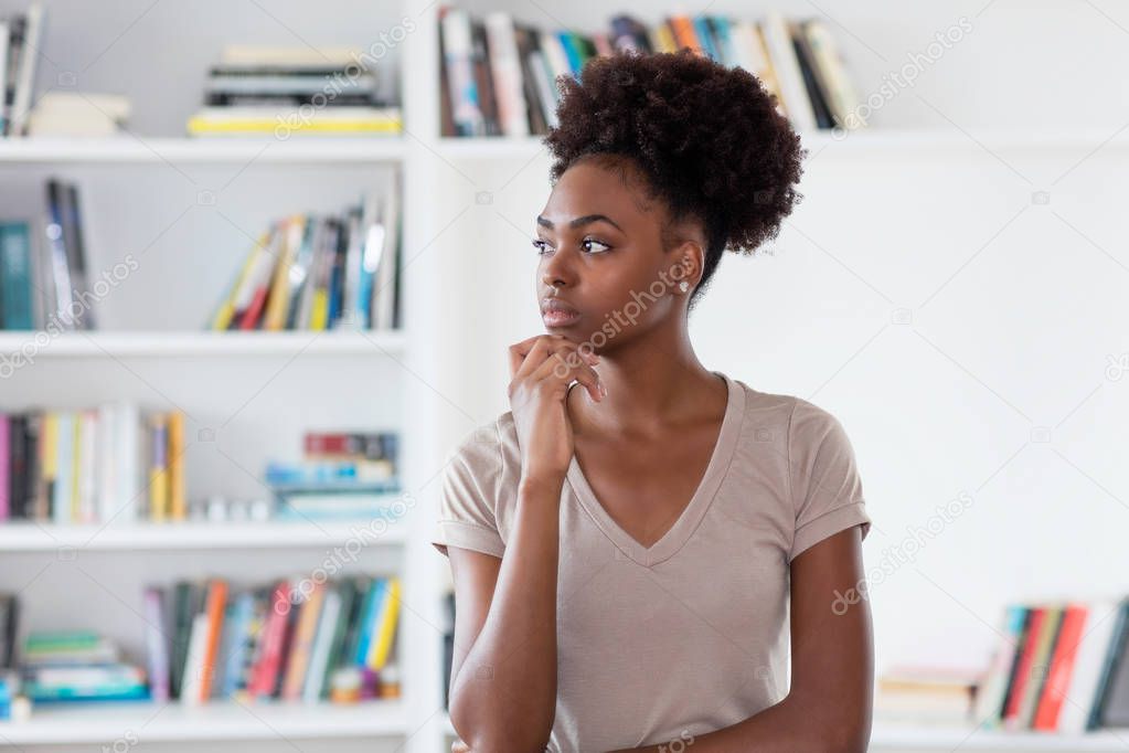 Thinking african american young adult woman indoors at home