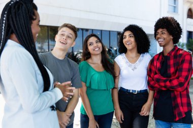 Latin Amerika Genç yetişkin insanlar ile Afrikalı kadın şehirde açık bahsediyorsun