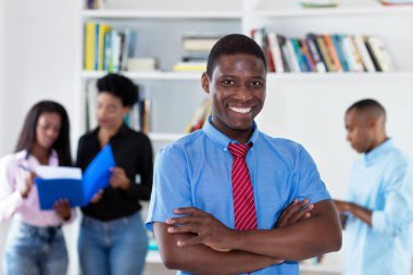 Afrika kökenli Amerikalı işadamı kravat ve arkadaşları ile ofiste gülüyor
