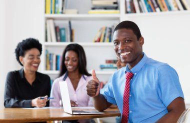 Takım ve yeni iş şirketin ofiste bilgisayar ile başarılı Afrikalı-Amerikalı iş adamı