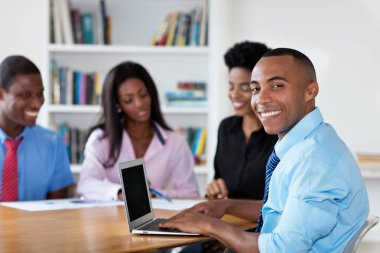 Takım ve yeni iş şirketin ofiste bilgisayar ile yakışıklı Afrikalı-Amerikalı işadamı
