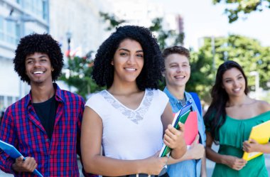 Latin Amerikalı kız öğrenci grup uluslararası öğrenci ile şehirde açık gülüyor