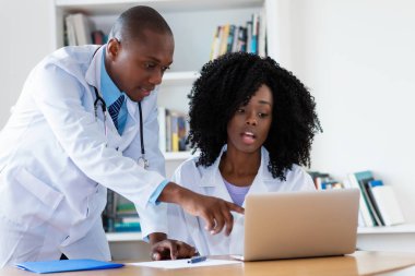 Afro-Amerikan erkek doktor ve hemşire hastanenin hastası söz