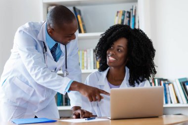 Afro-Amerikan erkek doktor ve hemşire Hastanesi'nde bilgisayar başında çalışırken