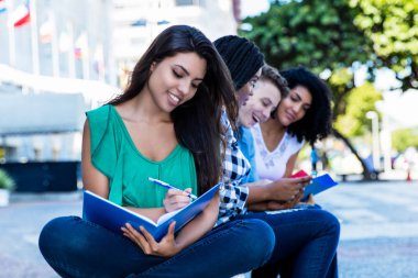 Mutlu öğrenme latin Amerikalı kız öğrenci grup uluslararası öğrenci yaz aylarında açık şehir ile