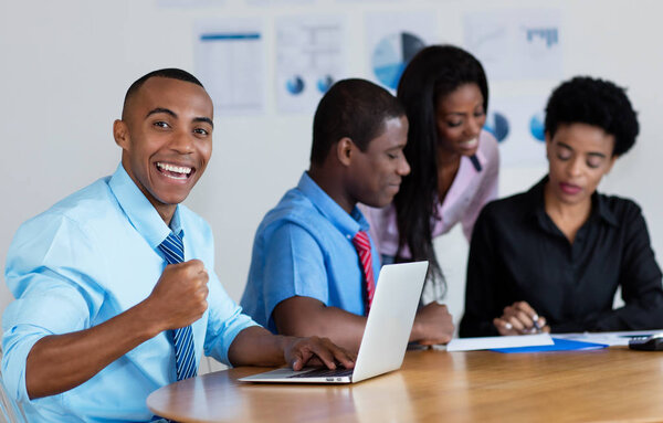 Happy african american businessman with business team at office of company