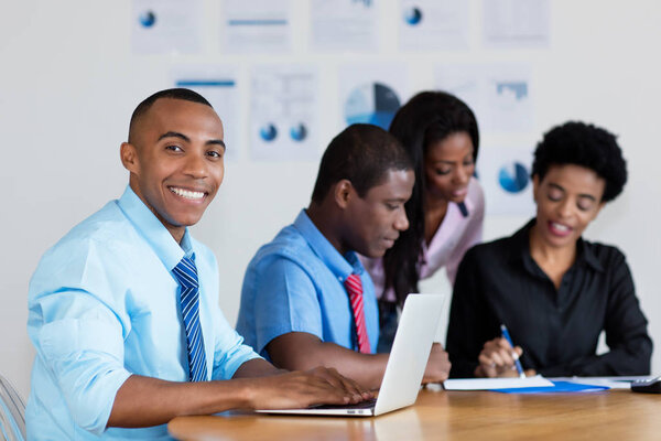 Handsome african american businessman with business team at office of company