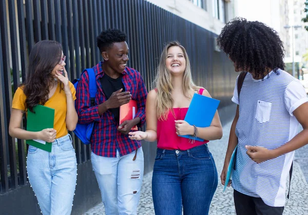 Grupp av fyra internationella studenter som går till universitetet — Stockfoto