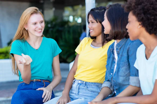 Junge erwachsene Frau mit roten Haaren im Gespräch mit Freundinnen — Stockfoto