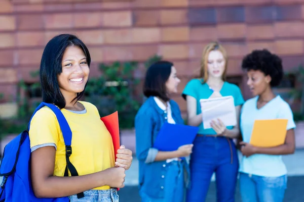 Native latin american female student with group of students — Stock Photo, Image