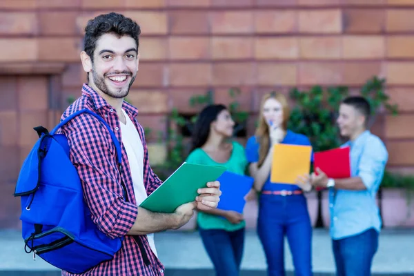 Smějící se španělský mužský student se skupinou studentů — Stock fotografie