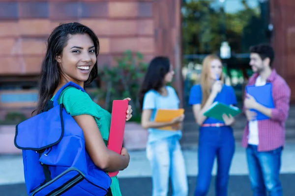 Happy latin american female student with group of students — Stock Photo, Image