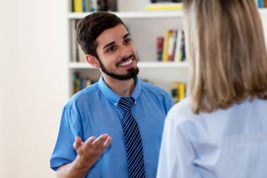 Gülen Meksikalı işadamı iş kadınıyla konuşuyor