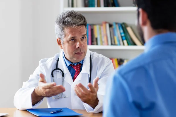 Mature doctor explaining treatment to patient — Stock Photo, Image