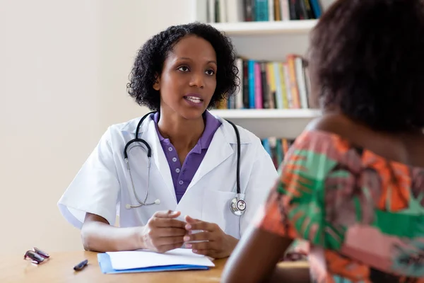 Афроамериканець жіночий лікар розмовляв з пацієнтом — стокове фото