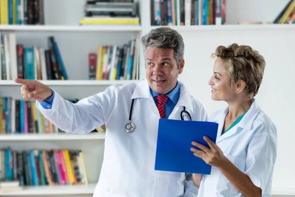 General practitioner talking about patient with female doctor — Stock Photo, Image