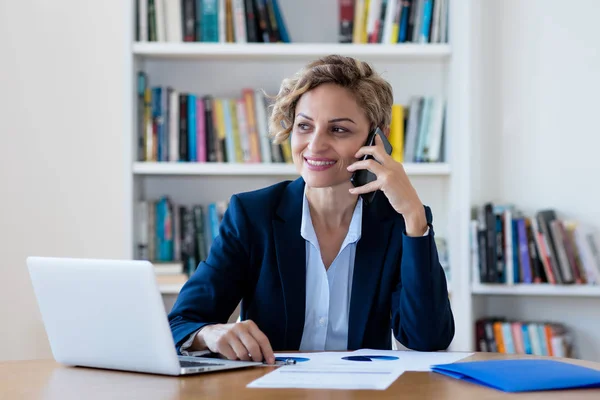 Volwassen zakenvrouw praten met client op telefoon — Stockfoto