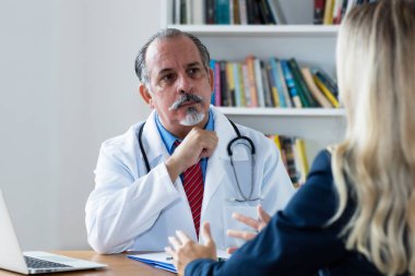 Kadın hastayı dinleyen kıdemli doktor