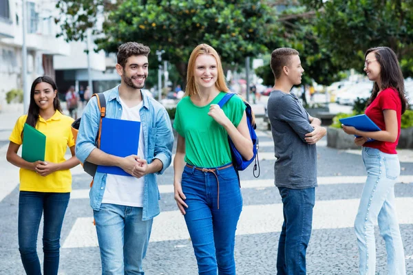 British female student and brazilian guy with group of mutliethn — Stock Photo, Image