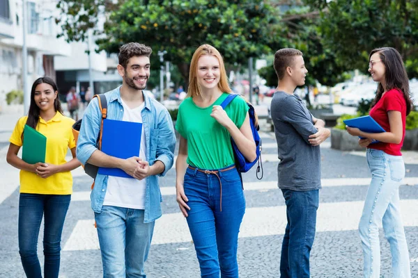 Brittisk kvinnlig student och brasiliansk kille med grupp av mutliethn — Stockfoto