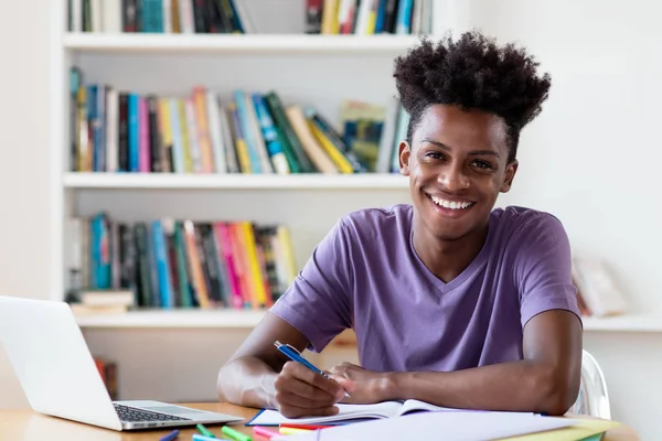 Rire afro-américain mâle étudiant l'apprentissage pour diplôme — Photo